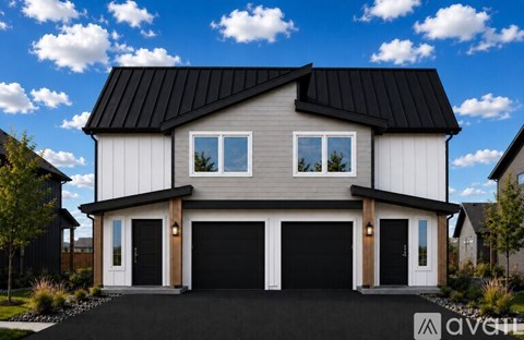 A modern house with a black roof and white walls.
