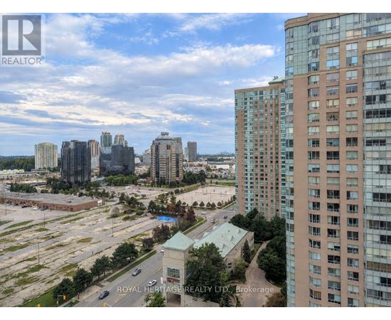 A cityscape with a mix of high-rise buildings and a parking lot.