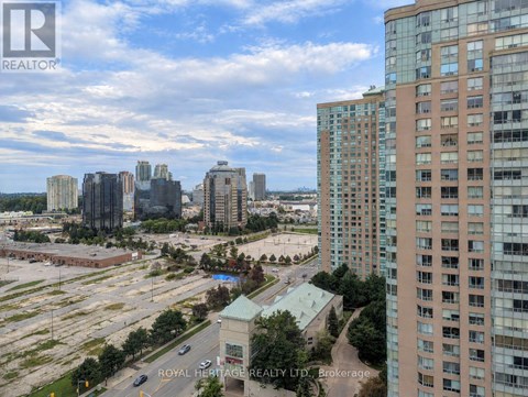 A cityscape with a mix of high-rise buildings and a parking lot.