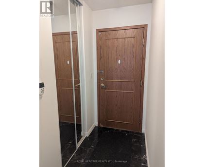 A hallway with two doors and a glass partition.