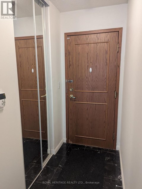 A hallway with two doors and a glass partition.