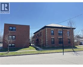 Two red brick buildings with a clear blue sky in the background.