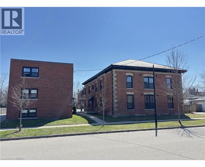 Two red brick buildings with a clear blue sky in the background.