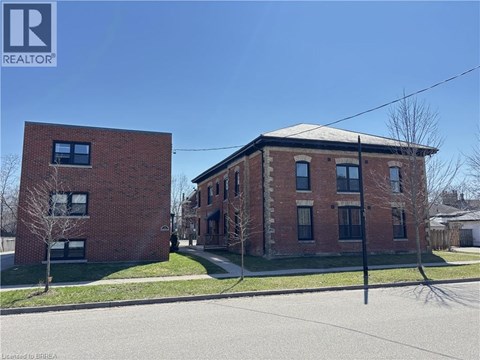 Two red brick buildings with a clear blue sky in the background.