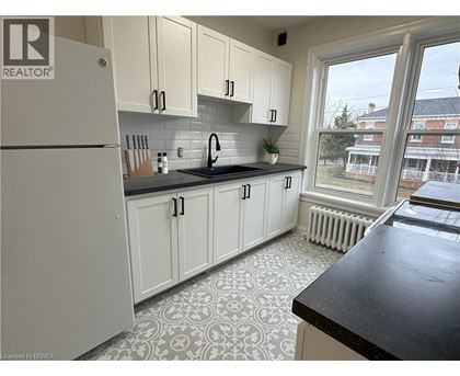 A kitchen with white cabinets and a black countertop.