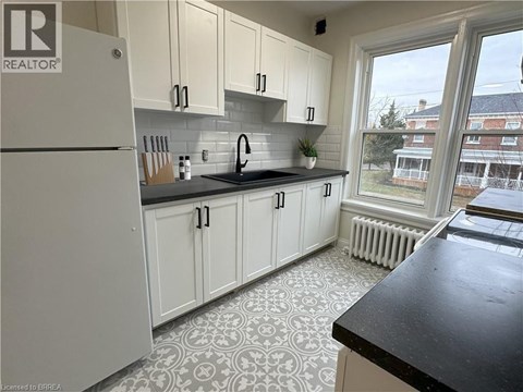 A kitchen with white cabinets and a black countertop.