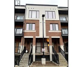 A building with a "For Rent" sign in front of it.