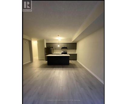 A spacious room with a kitchenette and a bed.