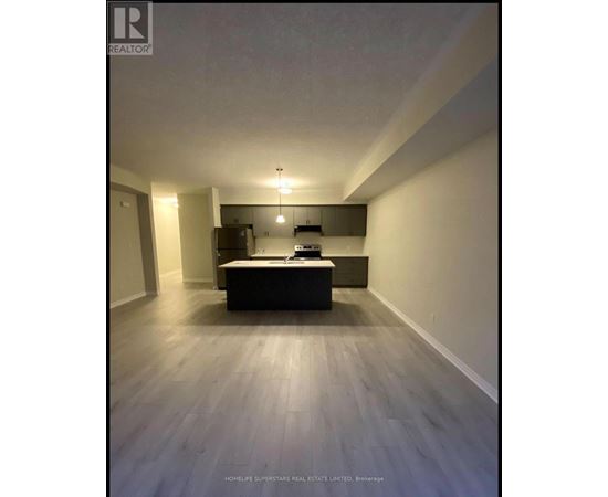 A spacious room with a kitchenette and a bed.