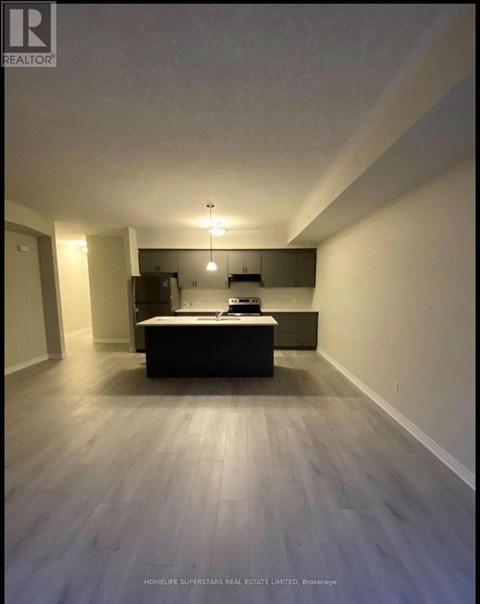 A spacious room with a kitchenette and a bed.