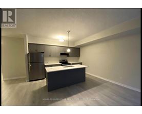 A kitchen with a refrigerator, microwave, and oven.