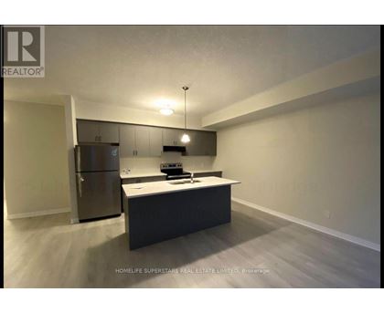 A kitchen with a refrigerator, microwave, and oven.