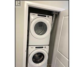 A white Whirlpool washing machine is installed in a cabinet.