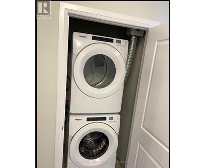 A white Whirlpool washing machine is installed in a cabinet.