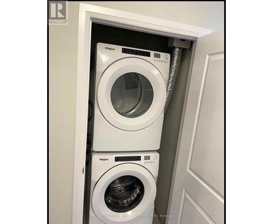 A white Whirlpool washing machine is installed in a cabinet.