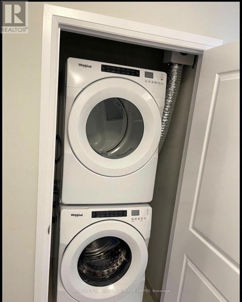 A white Whirlpool washing machine is installed in a cabinet.