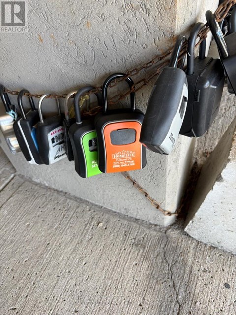 A row of padlocks are attached to a chain and a post.