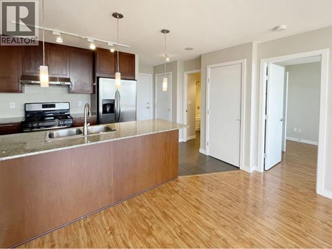 A kitchen with a stove top oven and a refrigerator.