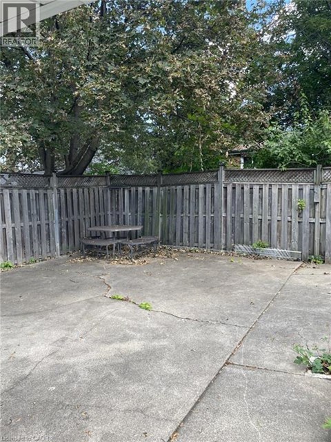 A backyard with a wooden fence and a tree.