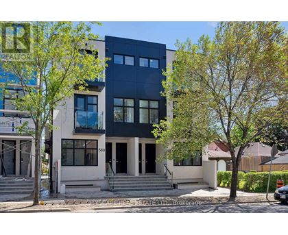 A modern two-story house with a black upper floor and a white lower floor.