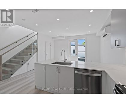 A modern kitchen with a stainless steel dishwasher and white cabinets.