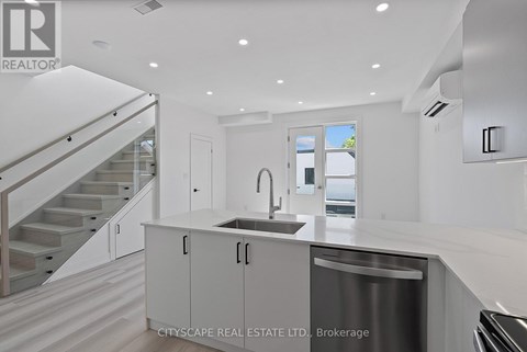 A modern kitchen with a stainless steel dishwasher and white cabinets.