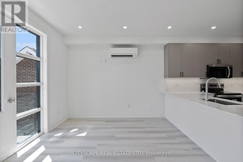 A spacious, empty room with a window, a white countertop, and a built-in oven.