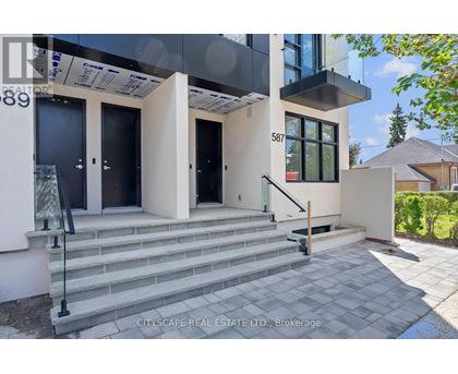 A modern house with a glass entrance and a staircase leading to the door.