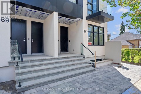 A modern house with a glass entrance and a staircase leading to the door.