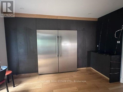 A modern kitchen with a stainless steel refrigerator and wooden accents.