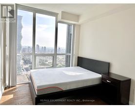 A bedroom with a large bed and a view of the city.