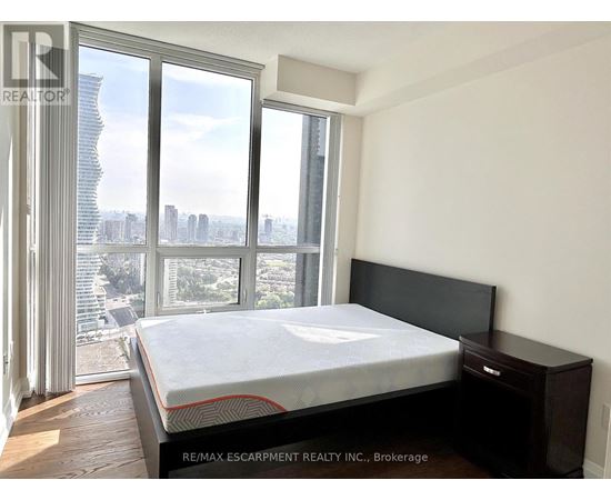 A bedroom with a large bed and a view of the city.