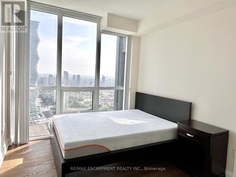 A bedroom with a large bed and a view of the city.