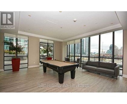 A living room with a pool table and a couch.