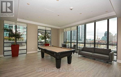 A living room with a pool table and a couch.