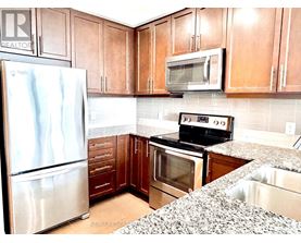 A kitchen with a stainless steel refrigerator, a microwave, and a stove top oven.