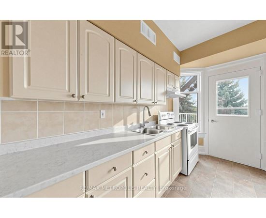 A kitchen with white cabinets and a beige countertop.
