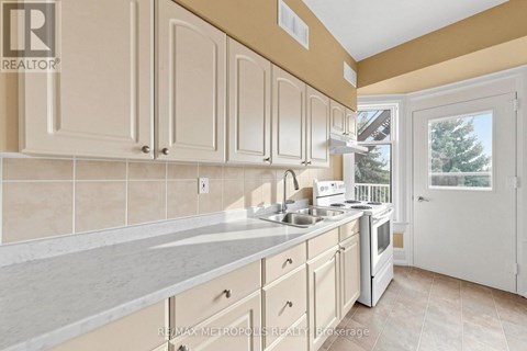 A kitchen with white cabinets and a beige countertop.