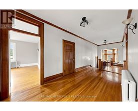 A spacious room with wooden floors and white walls.