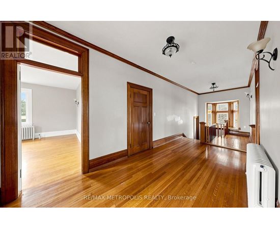 A spacious room with wooden floors and white walls.