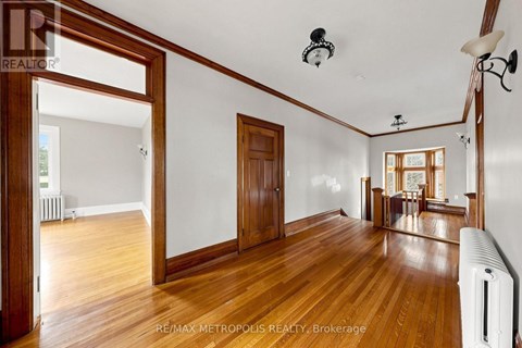 A spacious room with wooden floors and white walls.