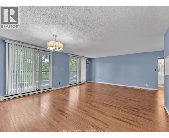 A room with wooden flooring and a ceiling fan.