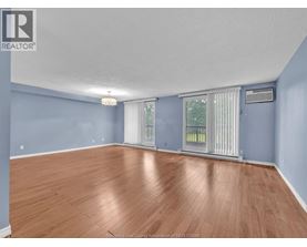 A spacious room with wooden flooring and blue walls.