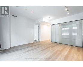 A spacious room with wooden flooring and white walls.
