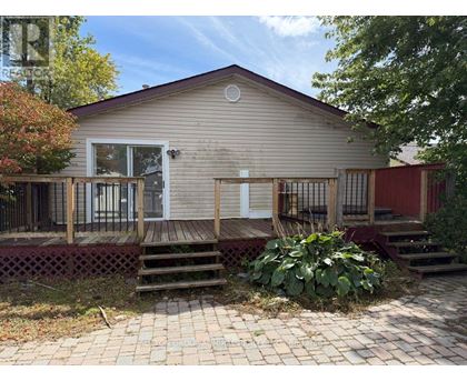 A small house with a red door and a porch.