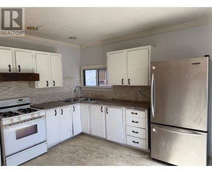 A kitchen with white cabinets and a stainless steel refrigerator.