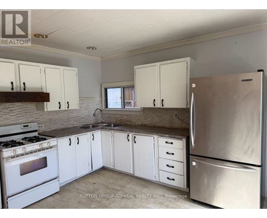 A kitchen with white cabinets and a stainless steel refrigerator.