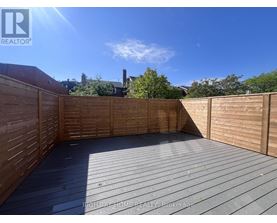 A wooden deck with a sunny sky in the background.