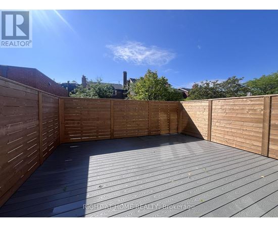 A wooden deck with a sunny sky in the background.
