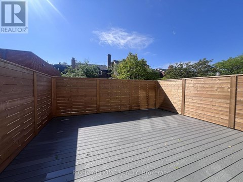 A wooden deck with a sunny sky in the background.